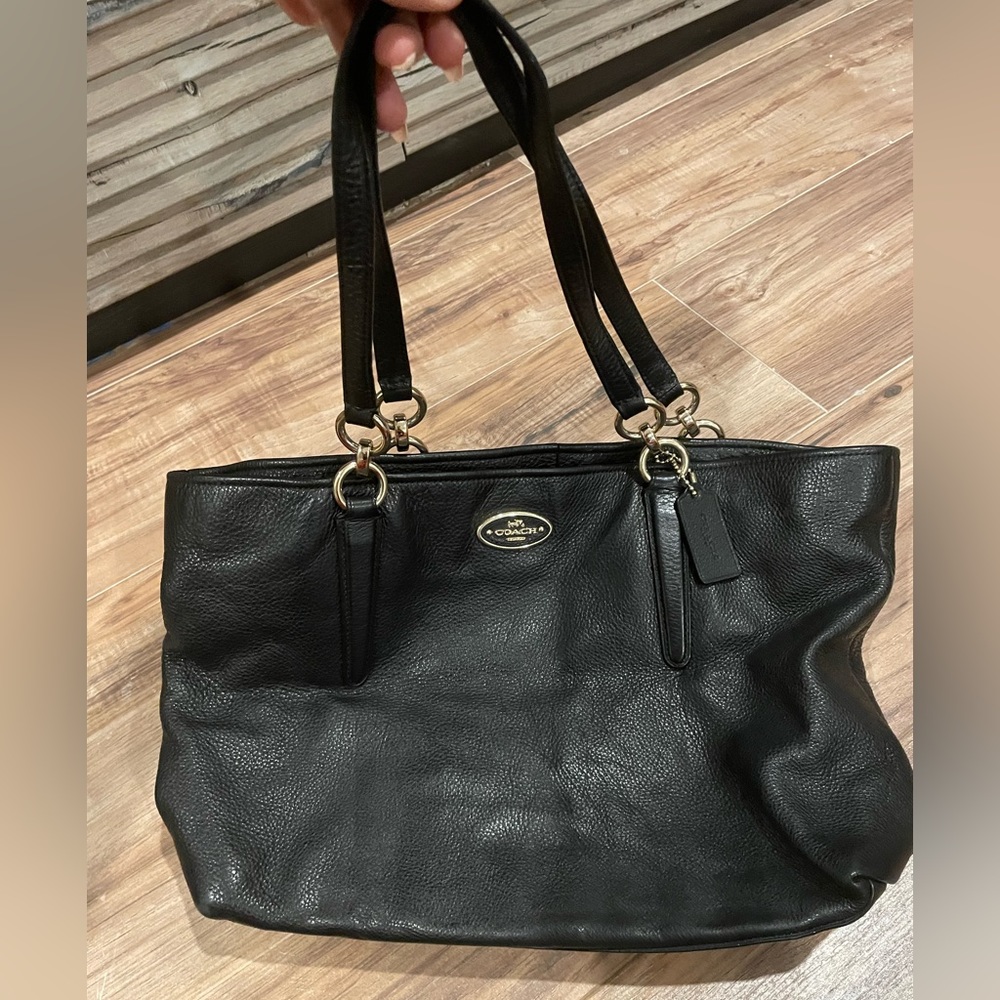 Black leather coach bag with gold hardware.